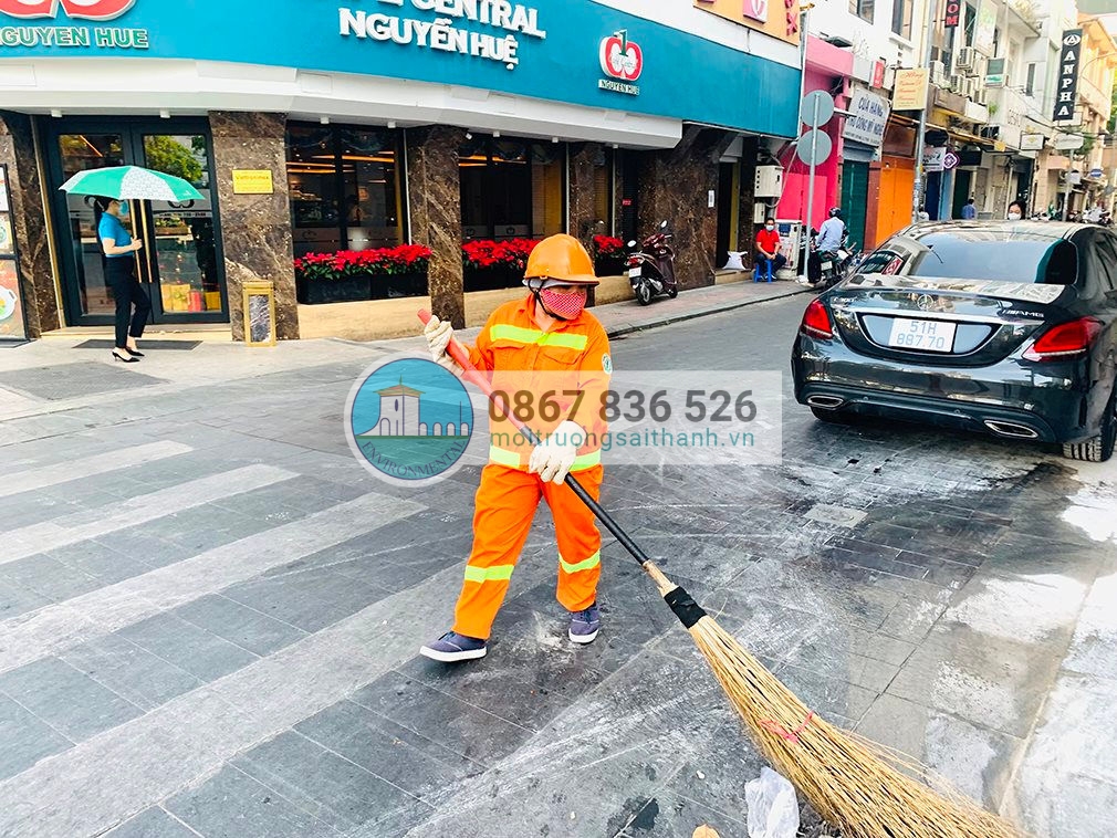 Công nhân vệ sinh môi trường TP.HCM đang quét dọn vệ sinh trên phố đi bộ Nguyễn Huệ sáng 24/12/2021.